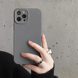 a woman holding a gray iphone case