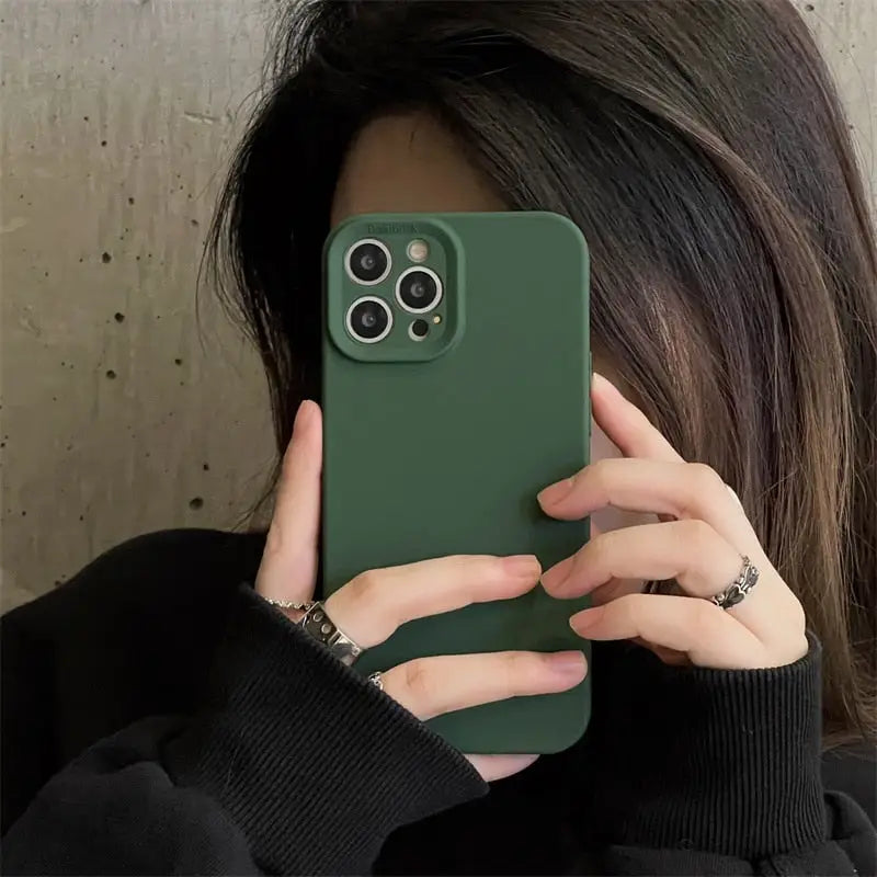 a woman holding a green iphone case