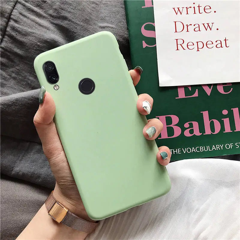 a woman holding a green iphone case