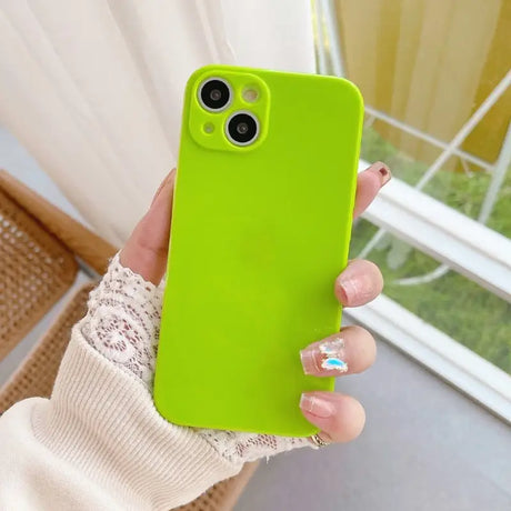 a woman holding a green phone case