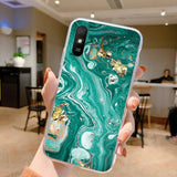 a woman holding up a green marble phone case