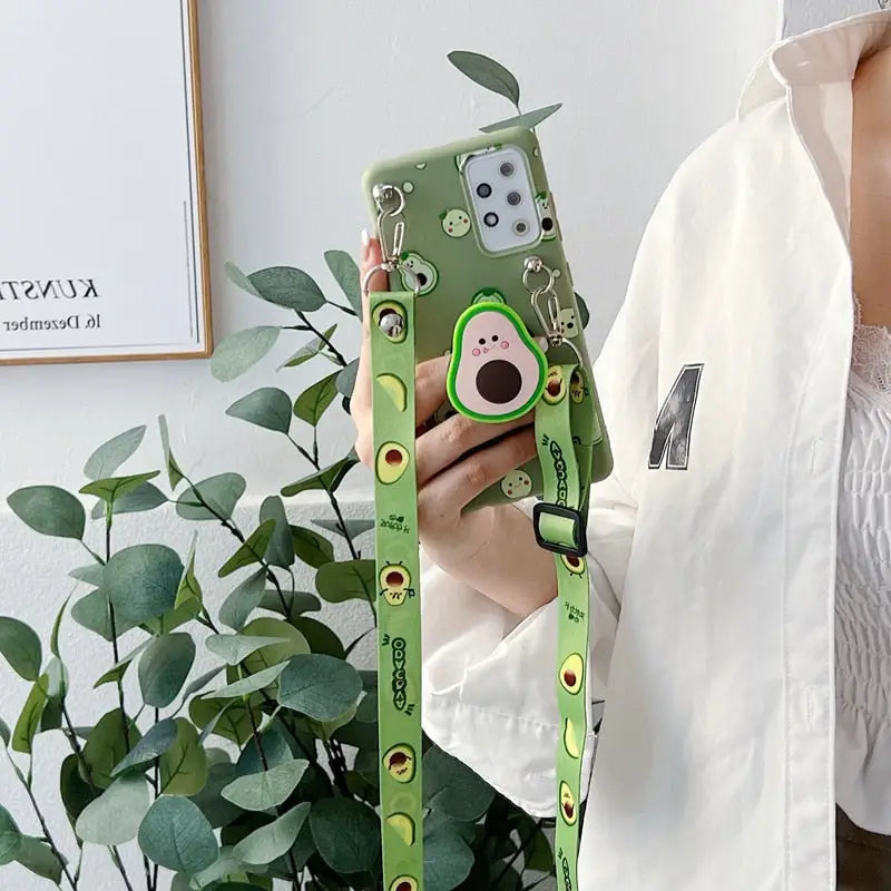 a woman holding a green phone case with a cartoon face