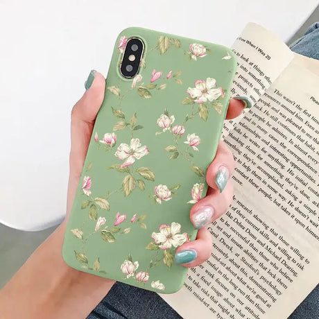 a woman holding a book and a green phone case