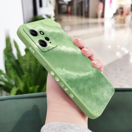 a woman holding a green phone case