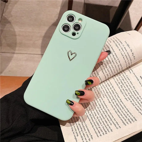 a woman holding a book and a phone case