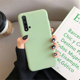 a woman holding a green phone case