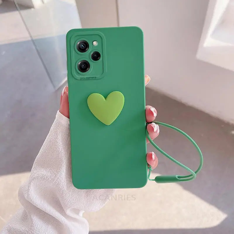 a woman holding a green phone case with a heart on it