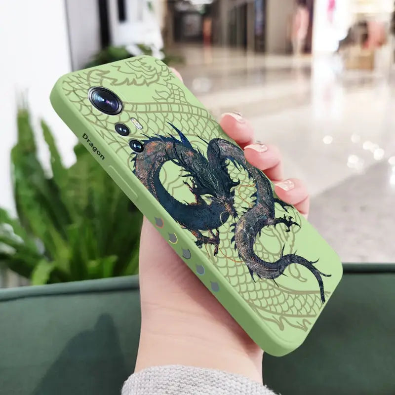 a woman holding a green phone case with a dragon on it