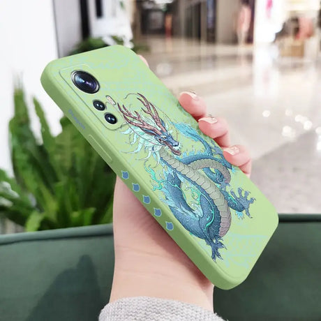 a woman holding a green phone case with a dragon on it