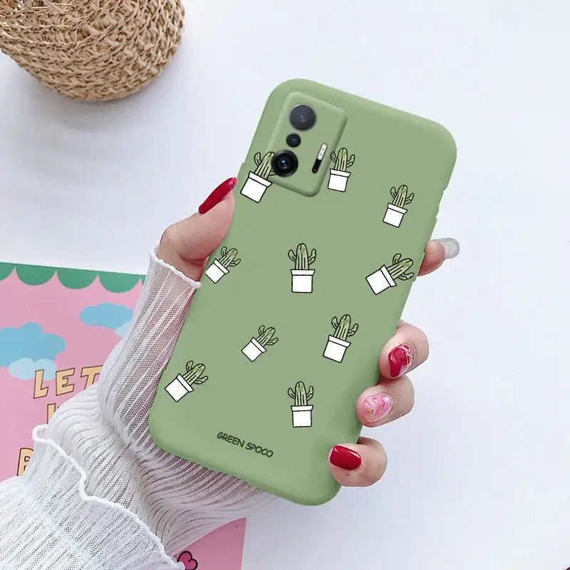 a woman holding a green phone case with cactus plants on it