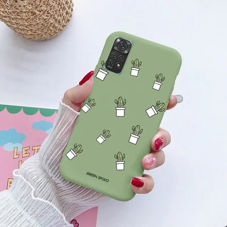 a woman holding a green phone case with cactus plants on it