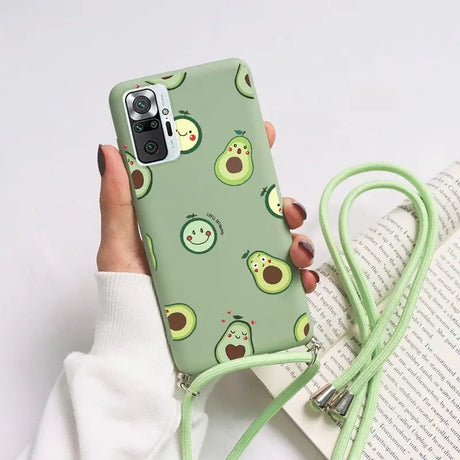 a woman holding a green phone case with avocas on it