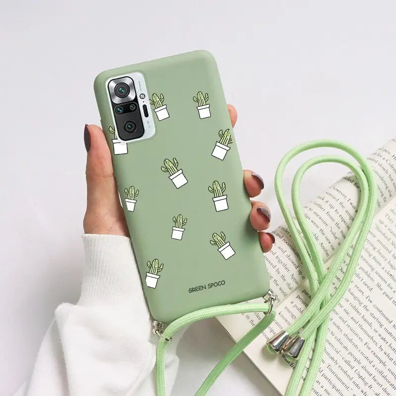 a woman holding a green phone case with cactus print