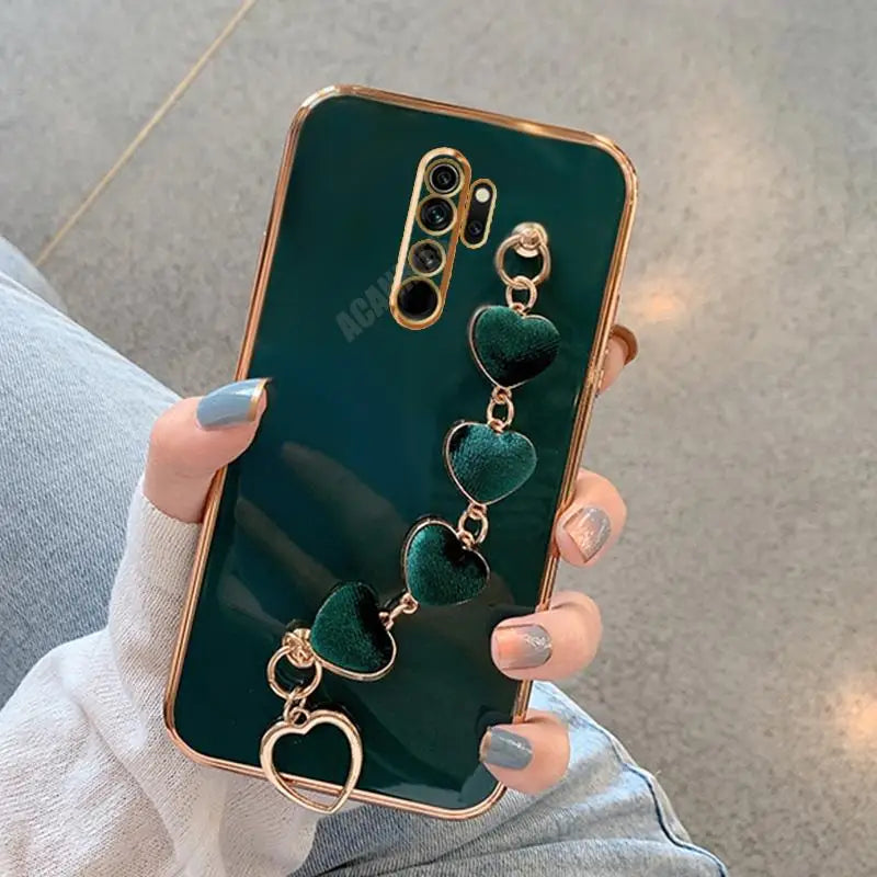 a woman holding a green phone case with heart charms