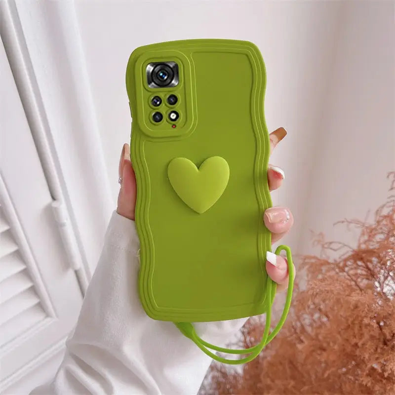 a woman holding a green phone case with a heart