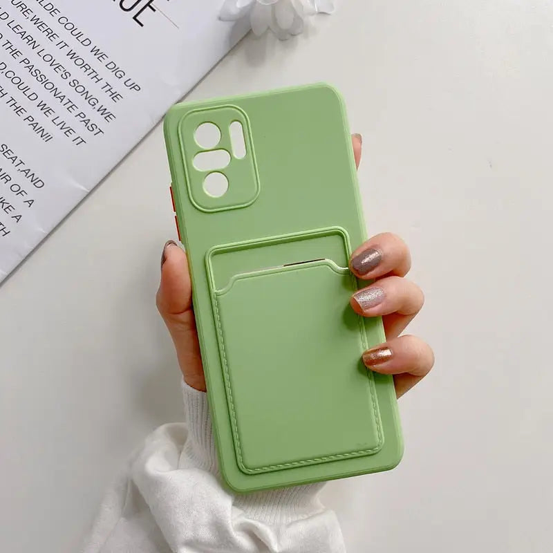 a woman holding a green phone case