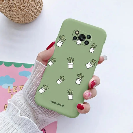 a close up of a person holding a green phone case with cactuses