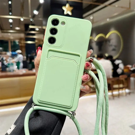 a woman holding a green phone case