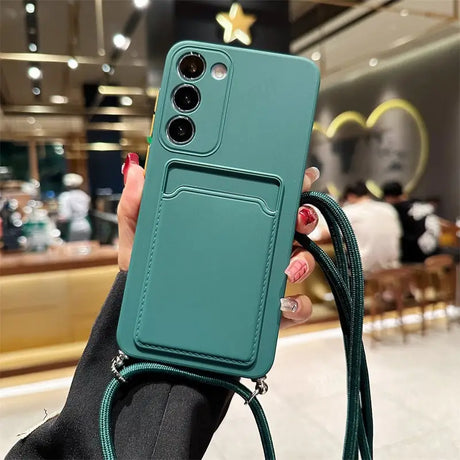 a woman holding a green phone case