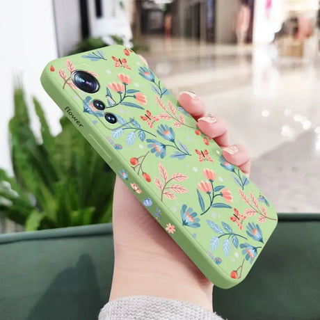 a woman holding a green phone case with a floral pattern