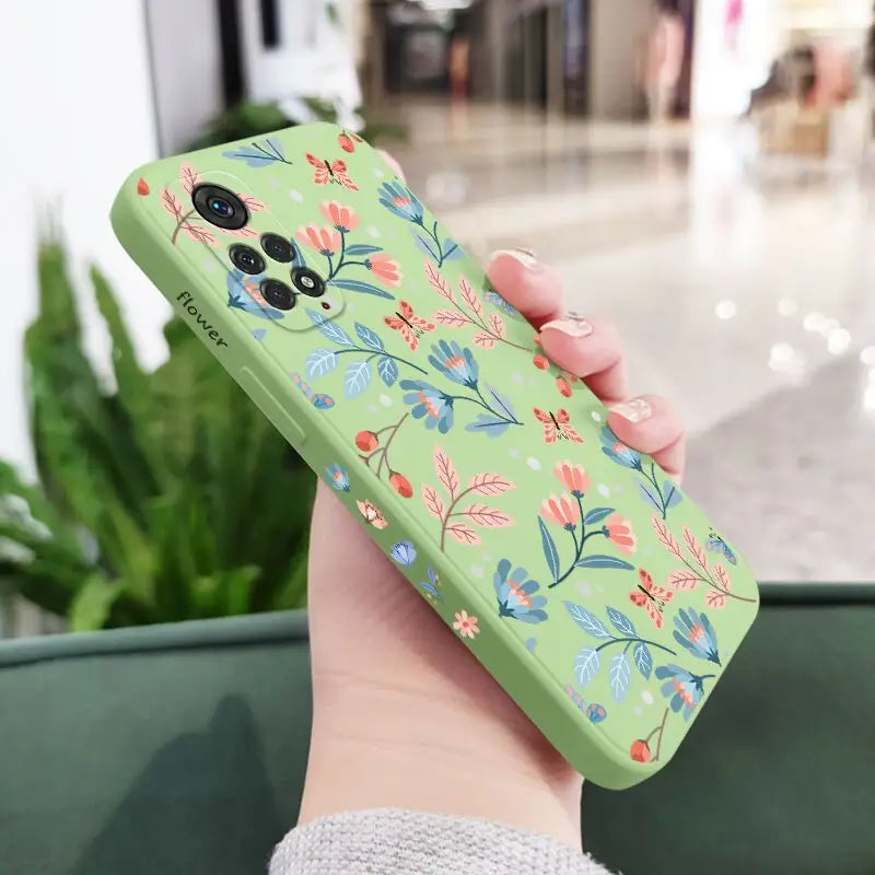 a woman holding a green phone case with a floral pattern