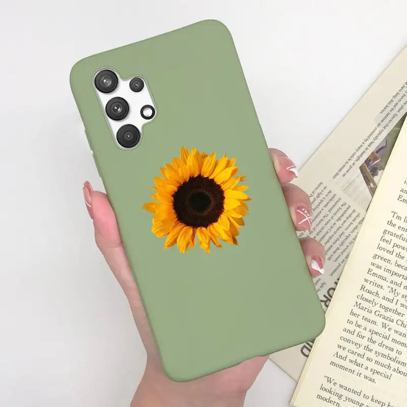 a woman holding a green phone case with a sunflower