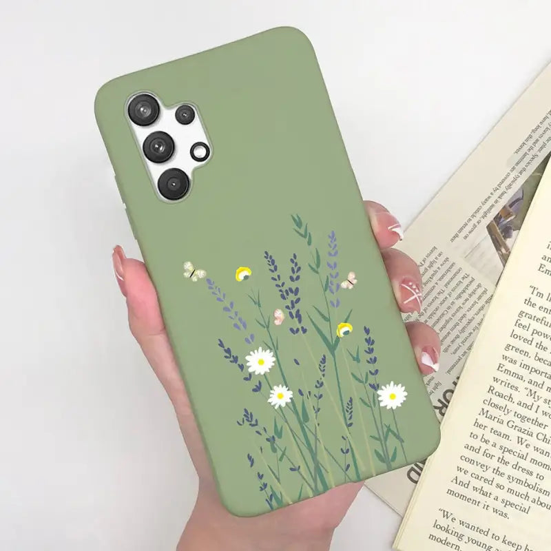 a woman holding a green phone case with flowers