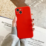 a woman holding a red iphone case