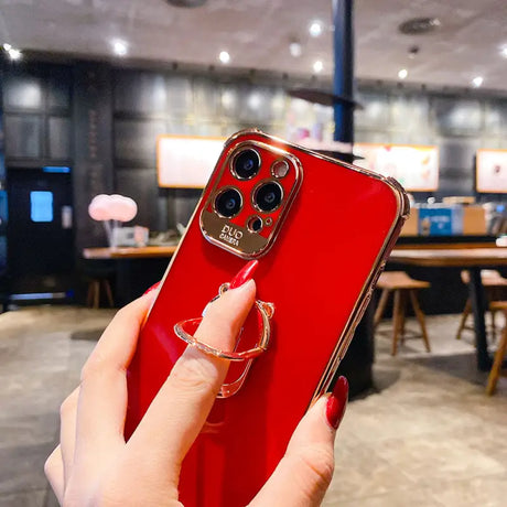 a woman holding a red iphone case