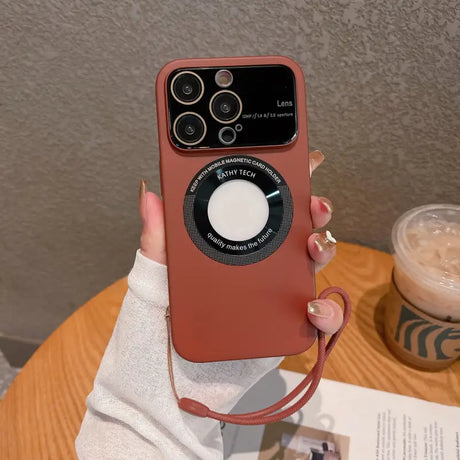 a woman holding a red iphone case with a camera attached to it