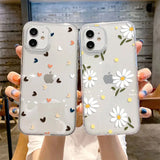 a woman holding two iphone cases with flowers on them