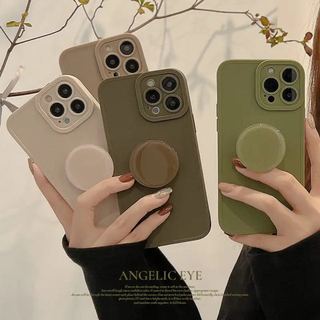 a woman holding two iphone cases with a phone holder