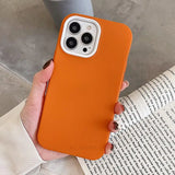 the orange iphone case is held up in a hand