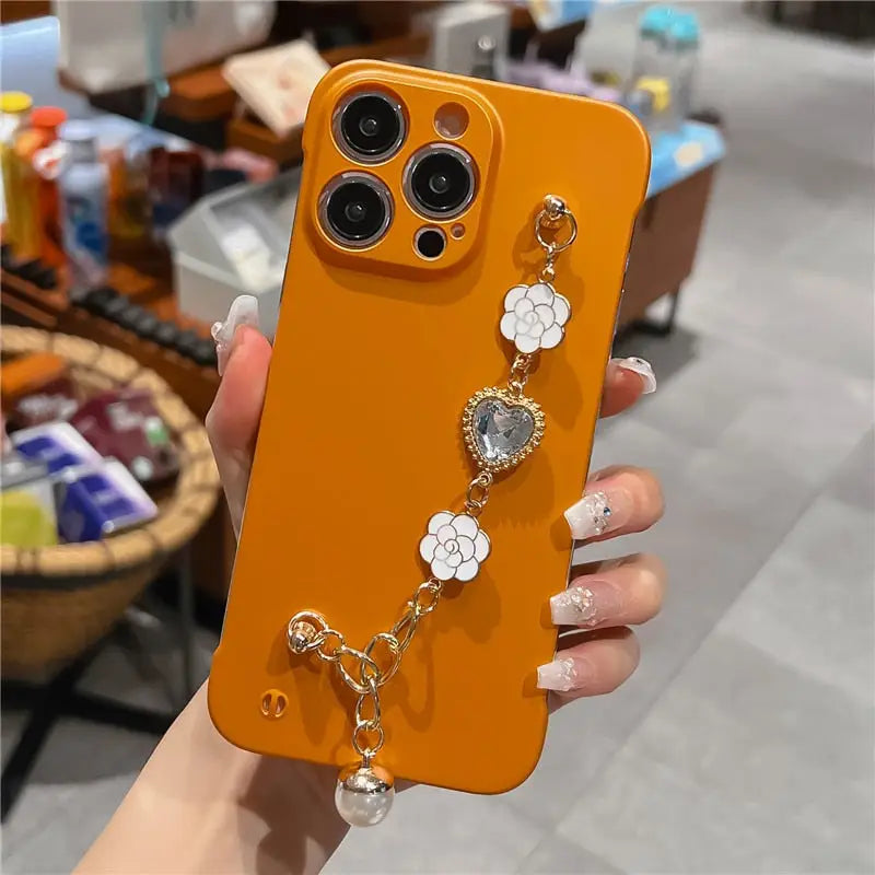 a woman holding an orange phone case with a flower design