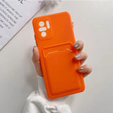 a woman holding an orange phone case