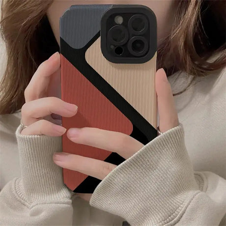 a woman holding a phone case with a red and black design