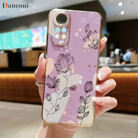 a woman holding a phone case with flowers on it