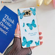 a woman holding a phone case with blue butterflies on it