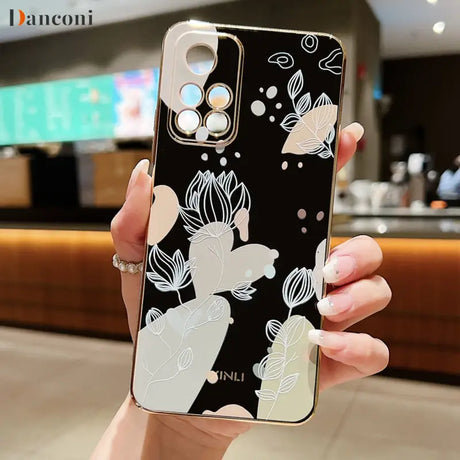 a woman holding up a phone case with flowers on it