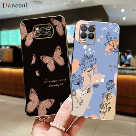 a woman holding up a phone case with butterflies on it