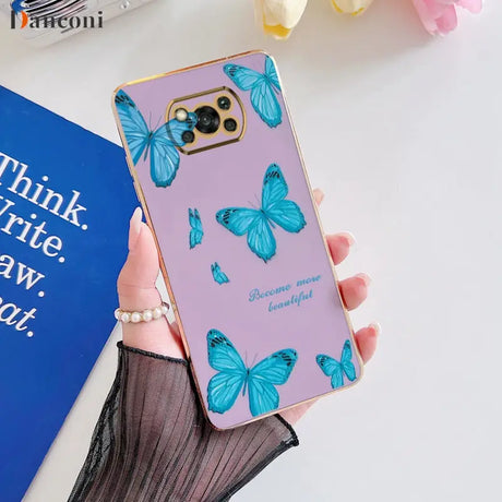 a woman holding a phone case with butterflies on it