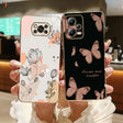 a woman holding up a phone case with butterflies on it