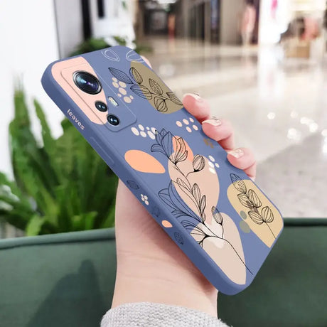 a woman holding a phone case with a floral pattern