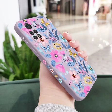 a woman holding a phone case with flowers on it