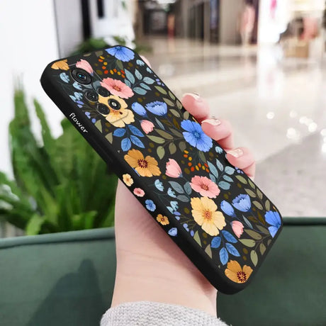 a woman holding a phone case with flowers on it