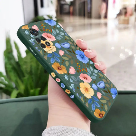 a woman holding a phone case with flowers on it