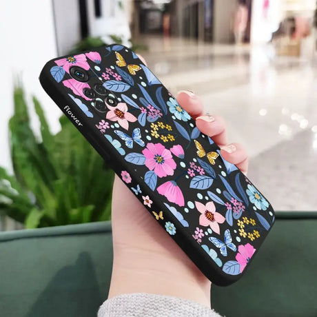 a woman holding a phone case with flowers on it