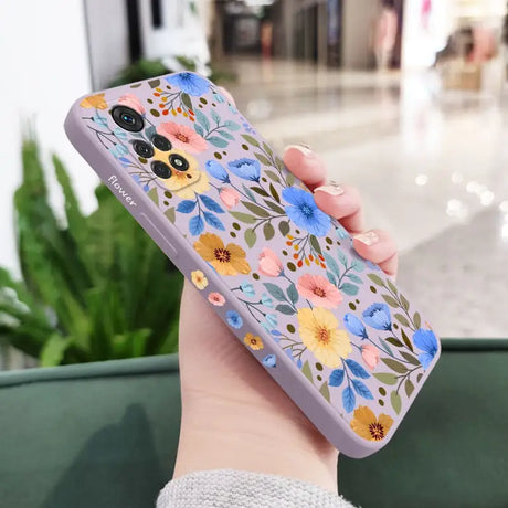 a woman holding a phone case with flowers on it