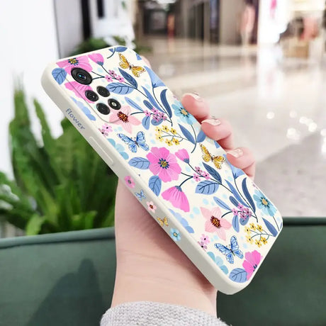 a woman holding a phone case with flowers on it