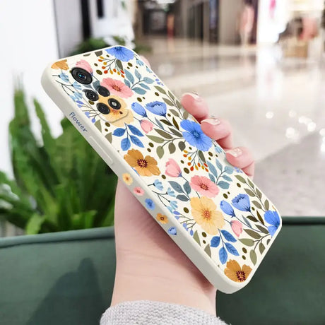 a woman holding a phone case with flowers on it